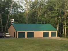 two cars parked in front of a garage with a green roof and side walkout