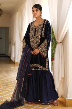 Navy blue straight kurta with gold zardosi, aari and kundan embroidery. Paired with a gharara and benarasi georgette dupatta.
Components: 3
Pattern: Embroidered
Type Of Work: Zardosi, Aari, Kundan
Neckline: Notched
Sleeve Type: Flared
Fabric: Kurta: Silk Velvet, Gharara: Satin Silk, Dupatta: Georgette Banarasi
Color: Blue
Other Details: 
Approx. product weight: 1.5 kg
Length:
Kurta: 33 inches
Gharara: 38 inches
Occasion: Mehendi and Haldi - Aza Fashions Dabka Embellished Sharara For Diwali Reception, Dabka Sharara For Diwali Reception, Diwali Reception Sharara With Dabka Embroidery, Blue Chinon Sharara With Cutdana Detail, Blue Chinon Sharara For Eid, Blue Unstitched Chinon Sharara, Blue Unstitched Sharara In Chinon, Blue Sharara With Traditional Drape In Chinon, Unstitched Blue Chinon Sharara