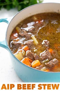 a blue pot filled with beef stew on top of a table