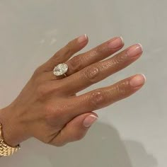 a woman's hand with a diamond ring on top of her left hand, against a white background