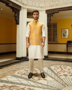 a man standing in a room wearing a yellow and white outfit