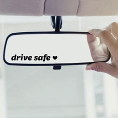 someone holding up a car mirror with the words drive safe on it