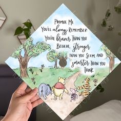 someone holding up a graduation cap with winnie the pooh on it