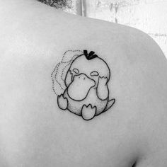 a woman's back shoulder with a small tattoo of a cartoon character on it