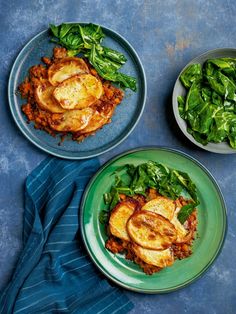 two plates with meat and spinach on them