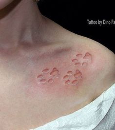 a woman with tattoos on her chest and paw prints