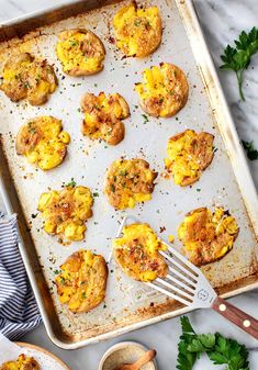 an overhead view of baked eggs on a baking sheet with a spatula next to it