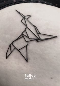 an origami bird tattoo on the back of a woman's head is shown