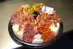 an assortment of meats and cheeses on a platter