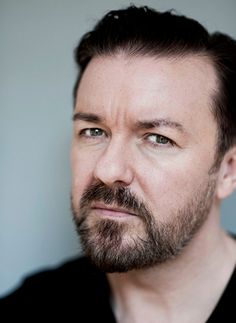 a close up of a person with a beard and black shirt looking at the camera