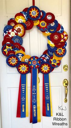 a wreath made out of red, white and blue ribbons hanging from the front door