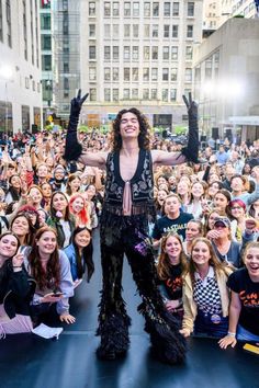 a woman standing on top of a stage in front of a large group of people