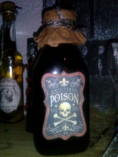 a bottle with a skull and crossbone label on it sitting next to other bottles