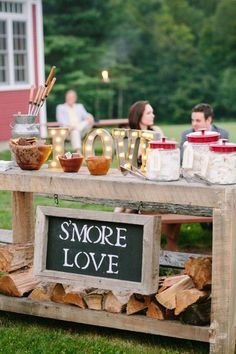 a table with some food on top of it and people in the background sitting around