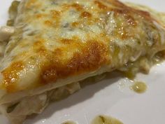 a close up of a piece of food on a plate with cheese and sauces