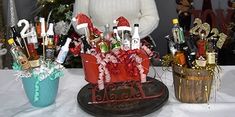 a woman standing next to two buckets filled with wine bottles and candy canes