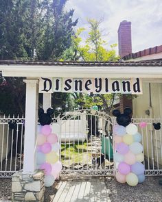 the entrance to disneyland land is decorated with balloons