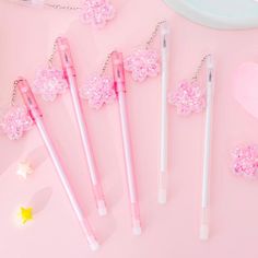 four pink and white pens sitting next to each other on a pink surface with stars