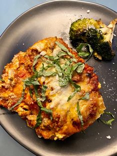 two pieces of pizza on a plate with broccoli and another piece of bread