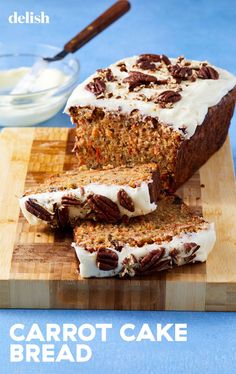 carrot cake with cream cheese frosting and pecans in the middle on a cutting board