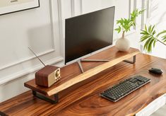 a wooden desk with a computer monitor, keyboard and mouse sitting on top of it