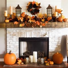 a mantel with candles, pumpkins and other autumn decorations on top of it