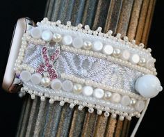 "This Apple watch band is lovingly hand embroidered with vintage beads  and a wide variety of embellishments and is backed securely with buttery  Ultra Suede. Silver-toned connectors attach this bracelet to your  38-40,41mm Apple watch. Because of the variety in bead hues, this watch band  coordinates well with all stainless steel, yellow gold, rose gold, silver, and  space gray cases.  This 1 1/4\" wide watch band is fully adjustable from wrist size 6\" and up  simply by creating an overhand knot (see diagram with video at bottom  of page) in expandable elastic to perfectly fit your wrist. Because you  customize the fit, the watch will hug snugly and comfortably." Handmade Adjustable Pink Watch Bands, Handmade Adjustable White Watch Bands, Handmade White Watch Bands For Gift, Handmade White Watch Bands As Gift, Handmade Pink Watch Bands As Gift, Overhand Knot, Bracelet Apple Watch, Vintage Beads, Apple Watch Band