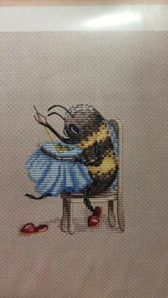 a cross stitch picture of a bee sitting on a chair