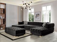 a living room filled with black couches next to a book shelf and window sill