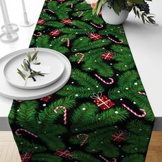 a christmas table runner with candy canes and candies on it, next to a white plate