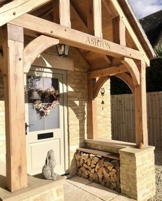 the front entrance to ashton's oakbydesign with logs stacked under it