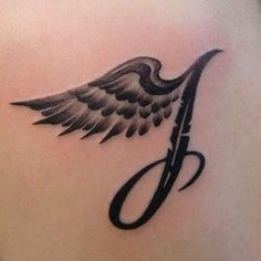 an angel wing tattoo on the back of a woman's shoulder