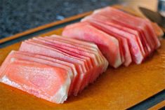 two pieces of meat sitting on top of a cutting board