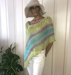 a mannequin wearing a colorful crochet ponchy with white pants