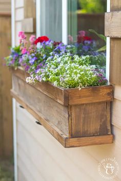 a window box with flowers in it and the words diy window box & shutters