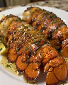 cooked lobsters on a plate with lemon wedges and parsley garnish