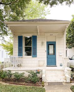 a small white house with blue shutters