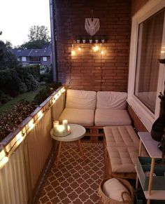 a small balcony with some lights on the wall and a couch in front of it