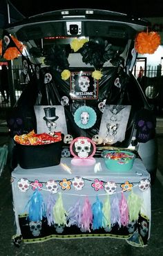 the trunk of a car is decorated with skulls, feathers, and decorations for halloween