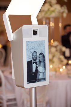 a photo frame attached to a metal pole with a white light on top of it