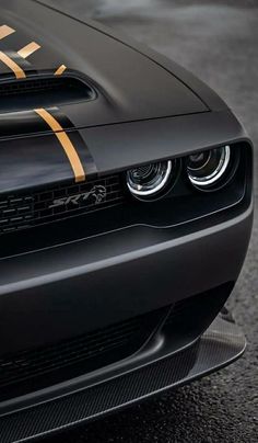 the front end of a black car with gold stripes