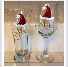 two wine glasses with santa hats on them