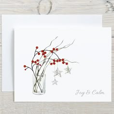 a white card with red berries in a vase