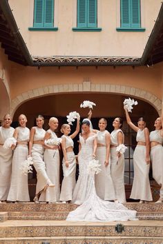 a group of women standing next to each other in front of a building