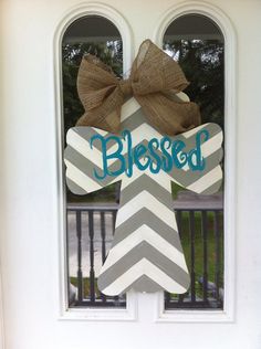 a door hanger decorated with a cross and a bow