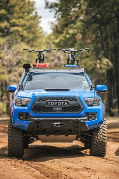 a blue toyota truck with two bikes on the roof