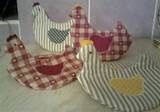 three chicken shaped pillows sitting on top of a table next to each other and one is red and white checkered