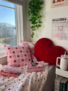 a heart shaped pillow sitting on top of a bed next to a window sill