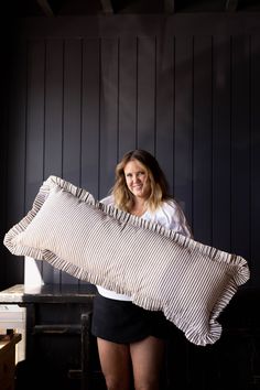 a woman holding a large pillow in her hands