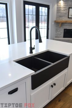 a kitchen with white counter tops and black sink faucets in the center island